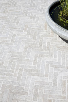 Beige Dijon paving cobbled laid in a herringbone pattern with a water center-piece. Herringbone Paving Patio, Cobble Stone Driveway Entrance, Limestone Patio Ideas, Outdoor Paving Ideas, Herringbone Paving, Tiled Porch, Porch Tiles, Forest Town