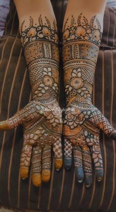 two hands with henna tattoos on them