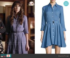 the young woman is wearing a blue shirt dress and black boots, which are also worn by