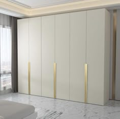 a bedroom with white and gold closets next to a large window on the wall