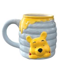 a winnie the pooh mug is shown with its mouth open and it's head sticking out