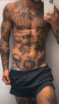 a man with tattoos on his body holding a cell phone