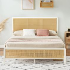 a bed with wicker headboard and foot board in a white room next to two pictures on the wall