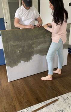 a man and woman standing in front of a painting