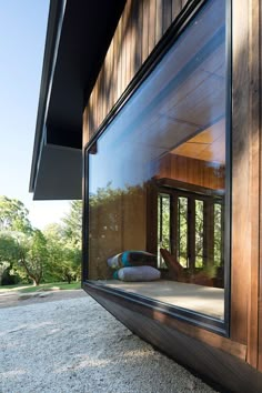 an open window on the side of a building with wood sidings and glass doors