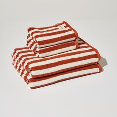 three red and white striped towels stacked on top of each other in front of a white background