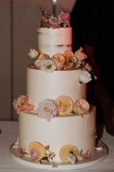 a three tiered cake decorated with flowers and lemons