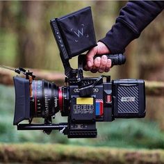 a person holding a camera in their hand with a wallet on top of the camera