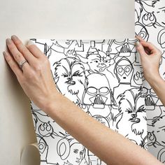 two hands on a piece of paper with black and white doodles