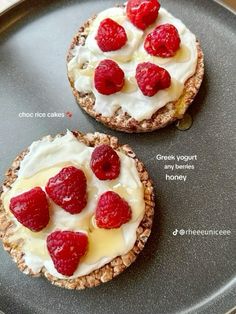 two desserts with raspberries and cream on them are sitting on a plate