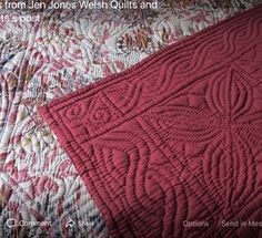 the quilt is red and white with an intricate design on it's back side