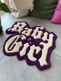 two purple and white rugs sitting on top of a floor next to a plant