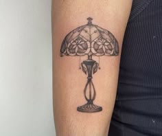 a tattoo on the arm of a woman with a lamp