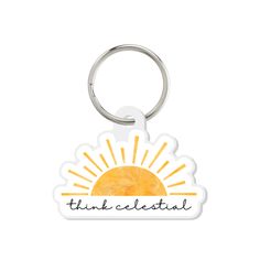 a white keychain with the words think celestial on it and an orange sun