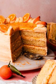 a cake with orange slices cut out of it on a plate next to another piece of cake