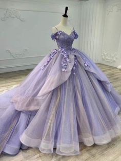 Make an unforgettable entrance with this enchanting Lavender Ball Gown Quinceanera Dress. This dress is crafted from layers of ethereal organza. The soft lavender hue is both delicate and captivating, perfect for celebrating your special day. The off-the-shoulder neckline beautifully frames your shoulders, adding a romantic and sophisticated touch. Adorned with intricate applique and shimmering beaded details, this dress catches the light with every movement, adding a hint of sparkle. The sweep Lavender Quinceanera Dresses, Lavender Quinceanera, Purple Sweet 16, Purple Ball Gown, Gaun Abad Pertengahan, Purple Quinceanera Dresses, Quinceanera Themes Dresses, Prom Inspo, Pretty Quinceanera Dresses