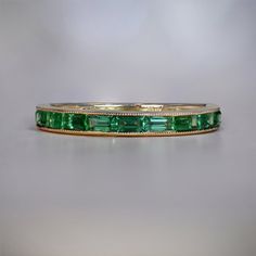 an emerald colored ring is shown on a table