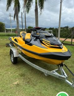 a yellow and black jet ski is parked on the grass