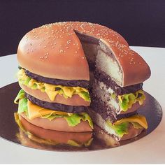 there is a giant cheeseburger that has been cut in half on a plate