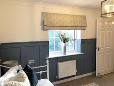 a living room with a couch, window and radiator next to the door