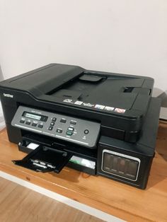 a printer sitting on top of a wooden table