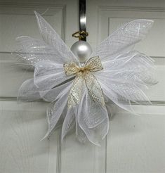 a door hanger with a white and gold bow