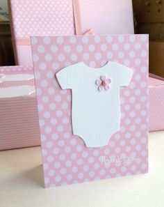 a card with a baby's body on it and pink polka dot boxes in the background