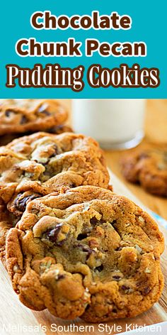 chocolate chunk pecan pudding cookies on a wooden cutting board with milk in the background