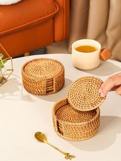 a table with two wicker trays on top of it next to a cup of tea