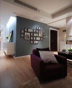 a living room filled with furniture and pictures on the wall