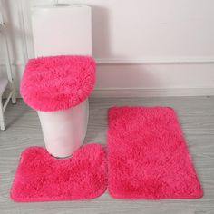 two pink rugs and a toilet in a bathroom