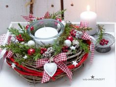 a christmas wreath with ornaments and a candle