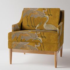 an upholstered chair with birds on it