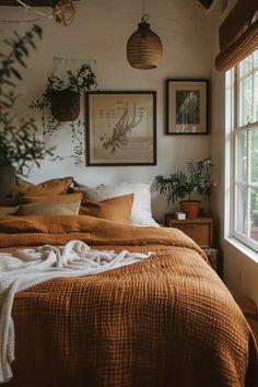 a bed sitting next to a window in a bedroom under two pictures on the wall