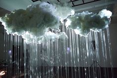 a chandelier with clouds hanging from it's sides and lights on the ceiling