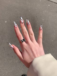 a woman's hand with black and white nail polish