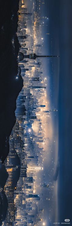 an aerial view of city lights at night from the water's edge, looking down on skyscrapers