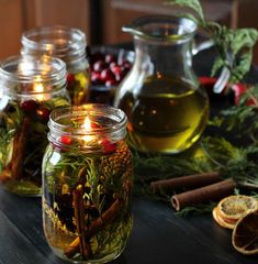 several jars filled with different types of herbs and spices on a table next to oranges