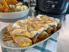 a plate with some food on it next to a bowl of pumpkins and an air fryer