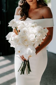 a woman holding a bouquet of white flowers