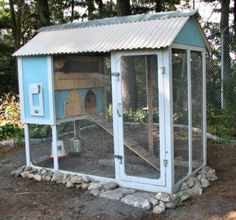 a chicken coop with a blue door and white roof