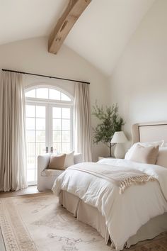 a bedroom with a large bed sitting next to a window and a chair in front of it