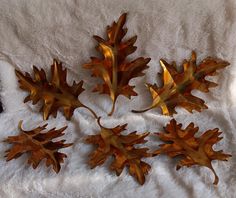 three metal oak leaf wall hangings on a white towel