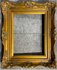 an antique gold frame with ornate designs on the edges and sides, is shown against a gray background