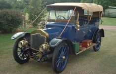 an old fashioned car parked in the grass