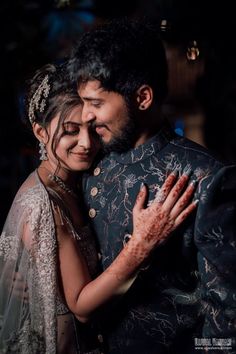 the bride and groom are hugging each other in their wedding photo session at night time