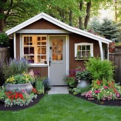 a small garden shed with flowers and plants around it