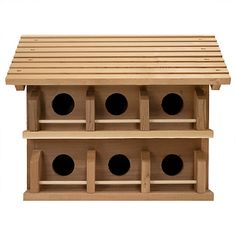 a wooden bird house with four holes in the roof