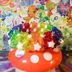 a mushroom with lots of gummy bears on it's top sitting in front of a wall