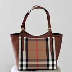 Burberry Canterbury House Check Derby Leather Tote In Tan Cotton Classic Check Panels With Brown Leather Side Panels One Interior Zip Pocket, Two Internal Patch Pockets Metal Feet At Base Black Lining Outer: 100% Cotton Panels/Base/Trim: 100% Calf Grain Leather 10.25x7x10” Made In Italy Nwt And Comes With A Dust Bag Burberry Check Tote Bag, Burberry Handbags 2022, Burberry Handbags Burberry, Burberry Giant Tote, Fake Burberry Handbags, Burberry Catherine Bag, Burberry Fragrance, Canvas Leather Tote, Base Trim